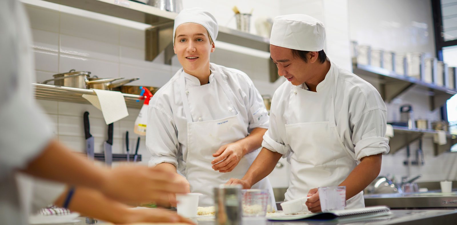 Vocational program students in a commercial kitchen wearing chef uniforms