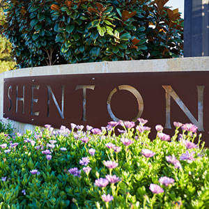 Shenton College entrance sign with flowers and trees