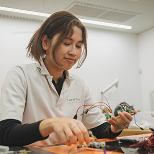A student working with wires and electronics.