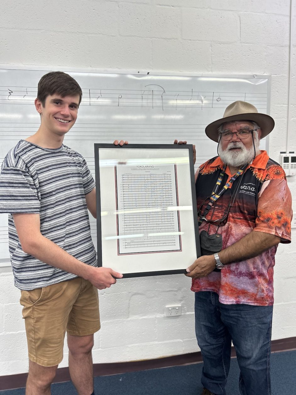 UNcle Noel Nannup stands with student , Lucas Edwards, both holding a framed piece of sheet music.